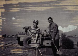 Two people with shovels in front of tractor