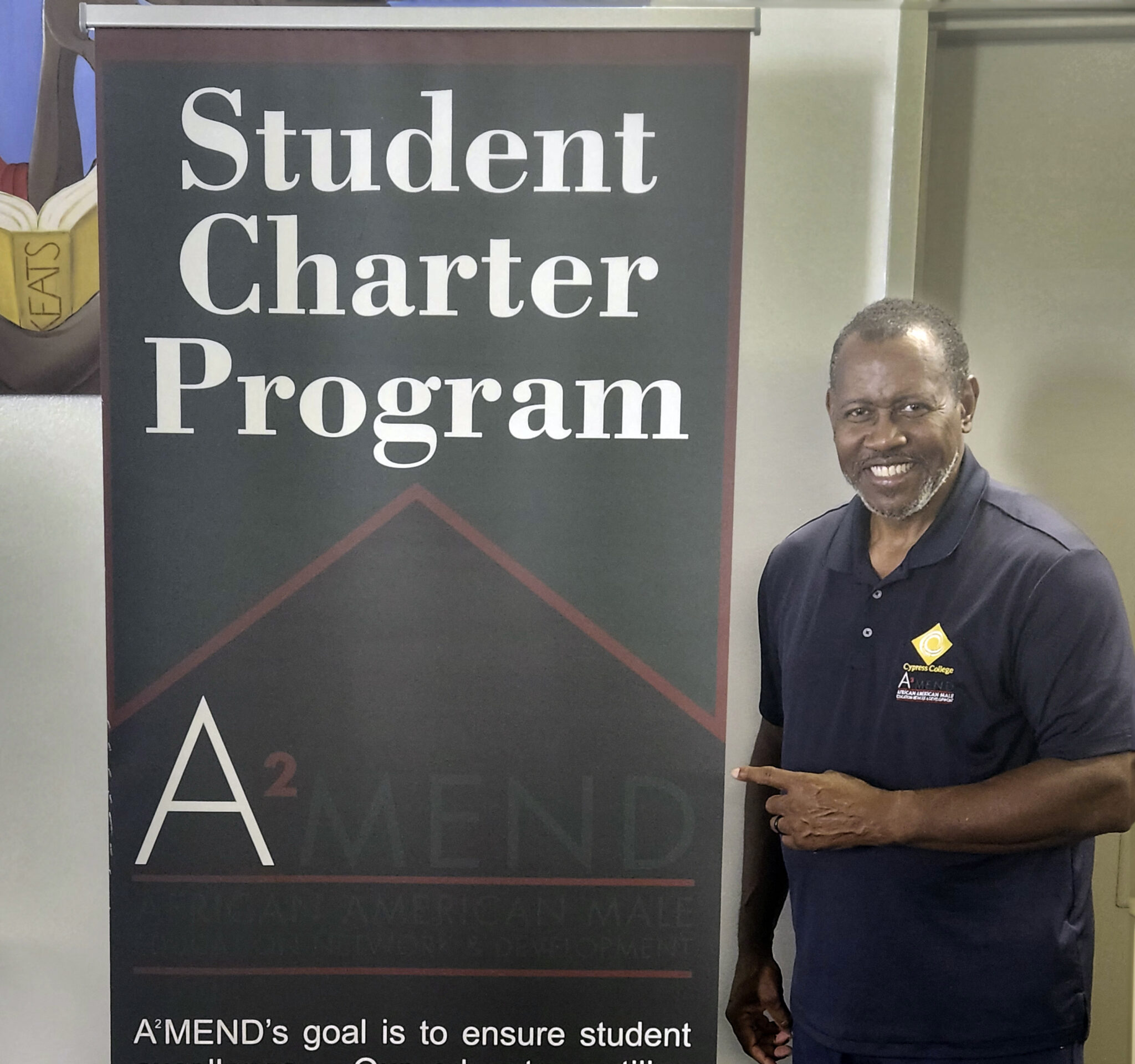 Virgil Adams stands beside sign promoting A2MEND