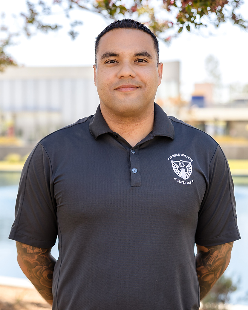 Benjamin Monroy, Adjunct Counselor, wearing a gray Cypress College Veterans polo shirt, standing in front of the VRC