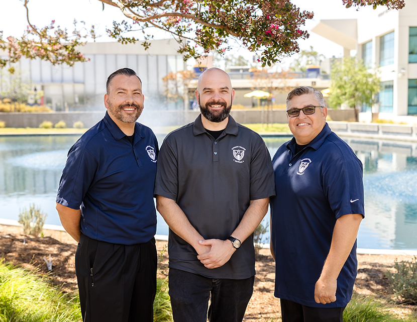 CCVO team Christopher Marr, Nick Gutierrez, Jaime Silva. Each person is wearing a veterans polo shirt, standing in front of the pond