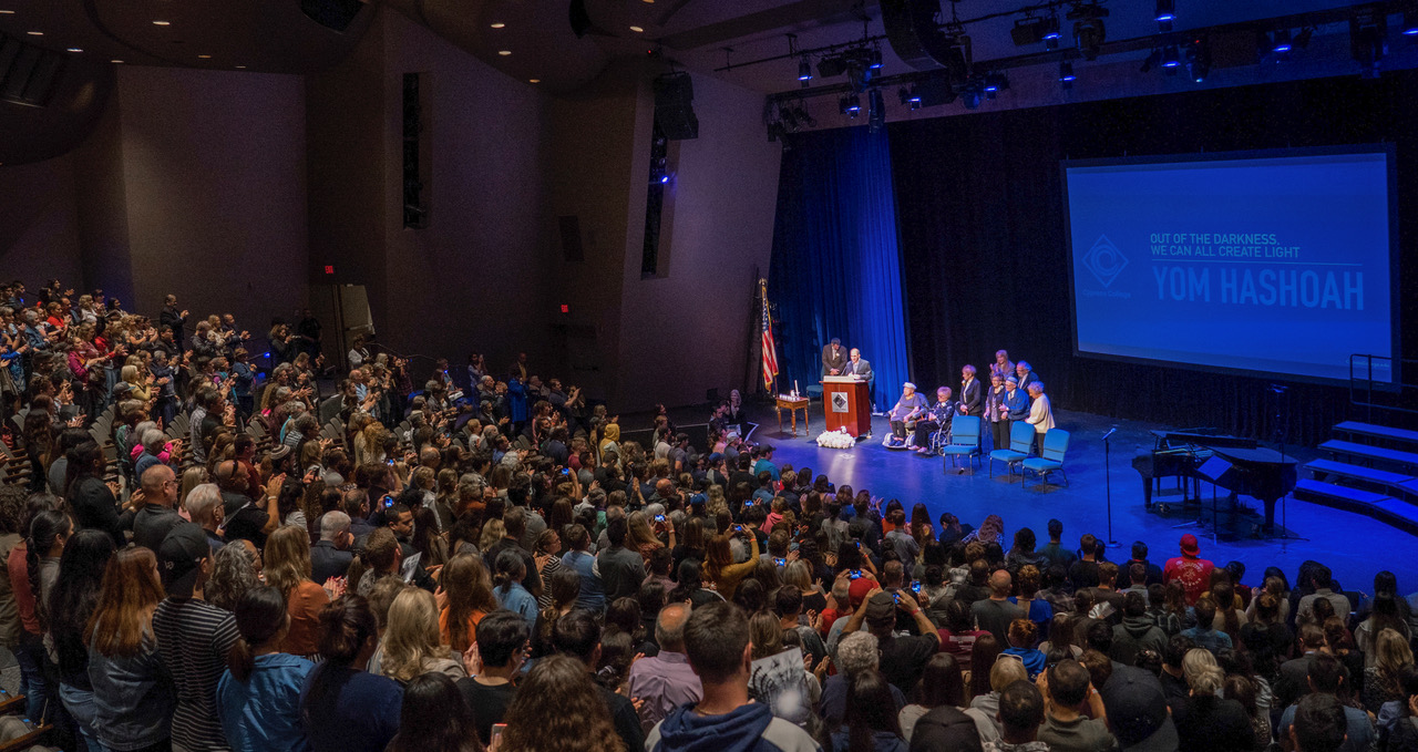 Attendees gather in the theater for the annual Yom HaShoah event