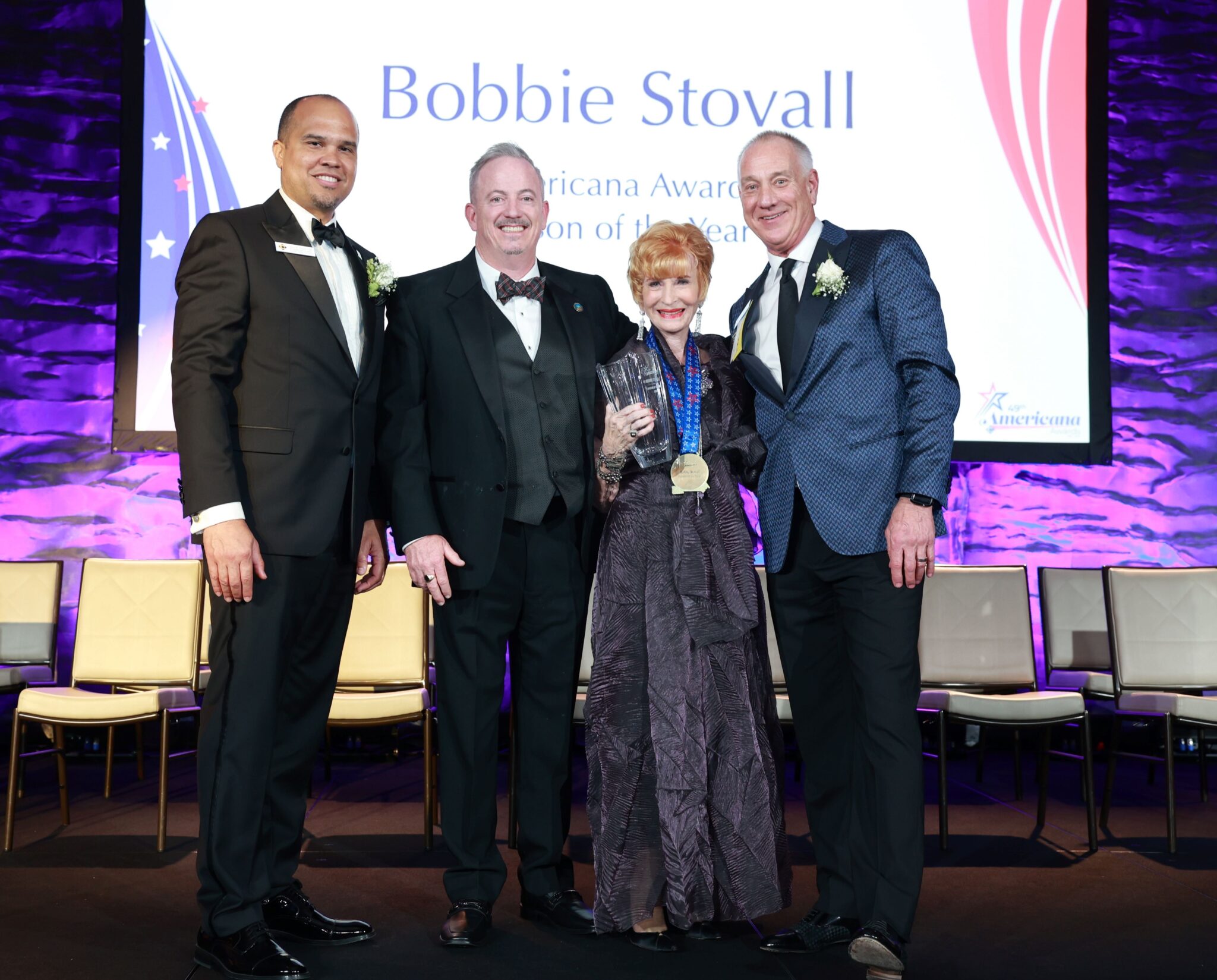 Person of the Year, Bobbie Stovall, posing on stage with her award alongside Dr. Scott Thayer, Jim Vanderpool, and Curtis Scheetz.