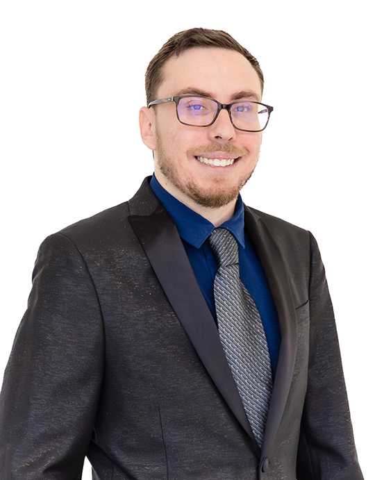 John Risenhoover wearing a dark blazer over a blue shirt standing against a white background, exuding a professional and confident demeanor.