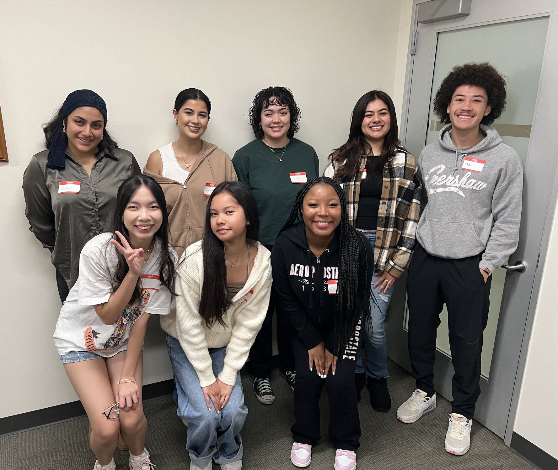 Male and female students standing in group smiling