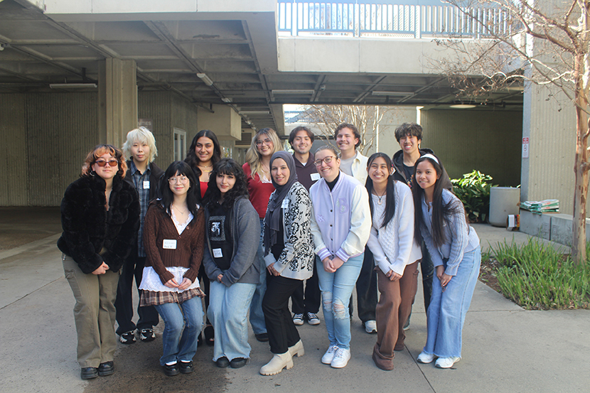 Male and female students standing in group smiling