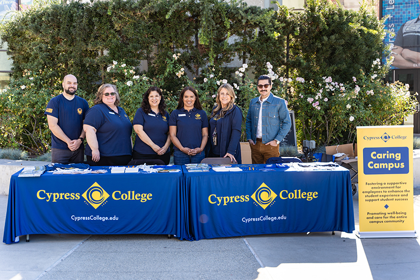 Members of Caring Campus standing behind tables with giveaway items