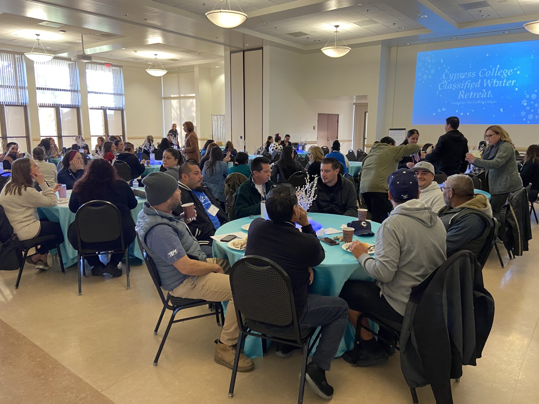 Classified staff sitting in groups for the Cypress College Classified Winter Retreat presentation.