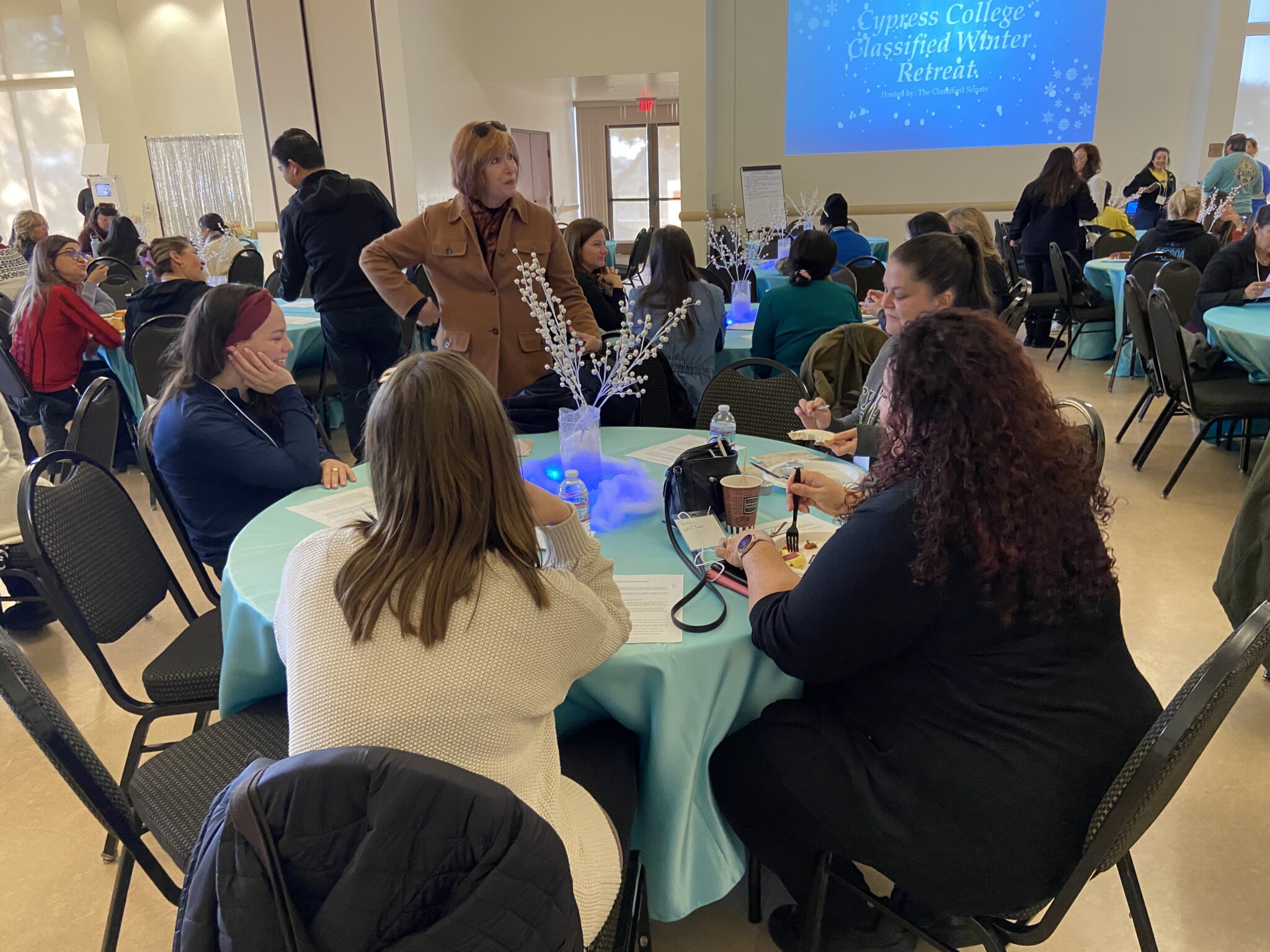 Dr. Schilling visiting a group at a table while they eat breakfast.