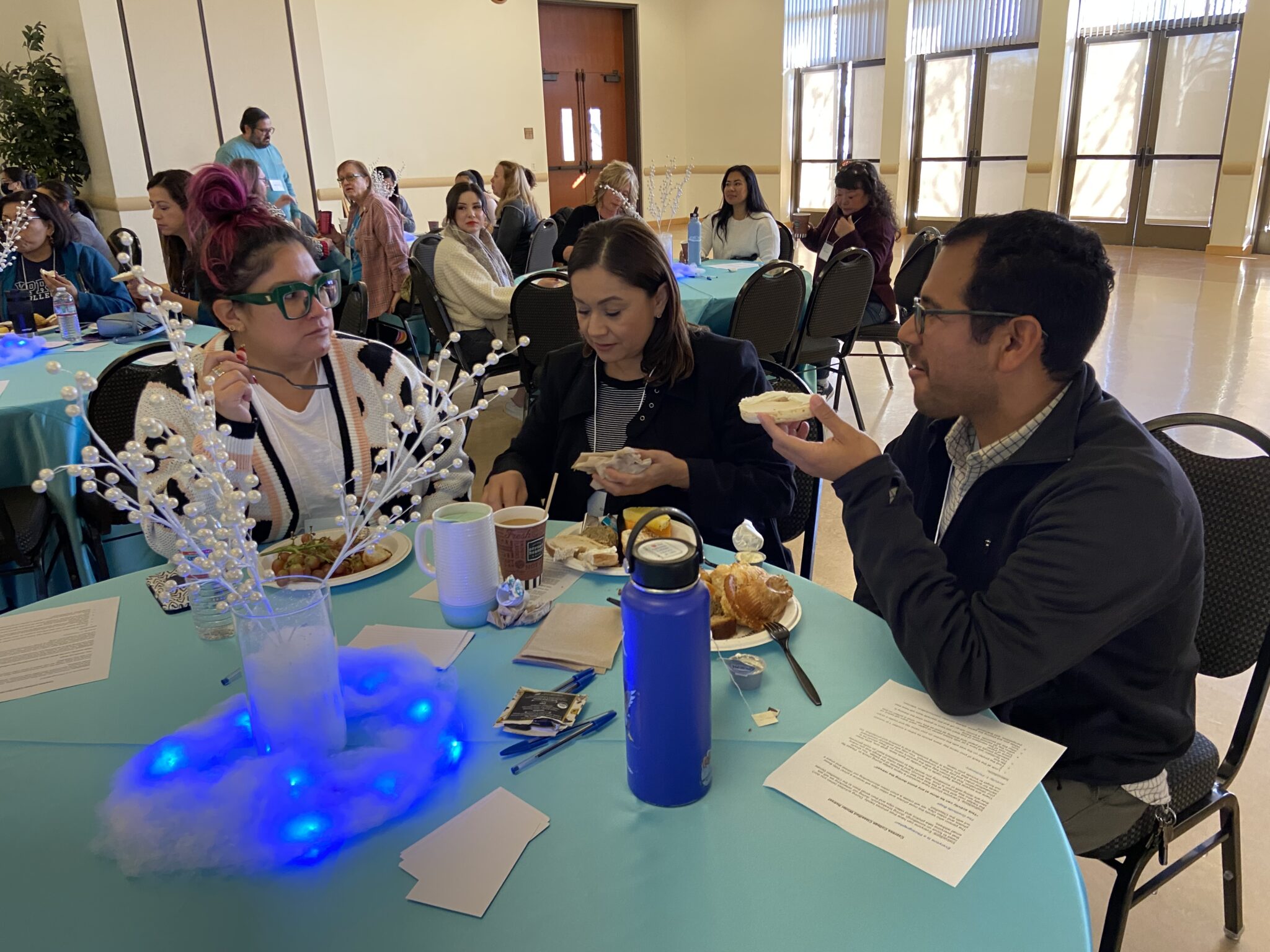 Three classified staff are eating breakfast and socializing.