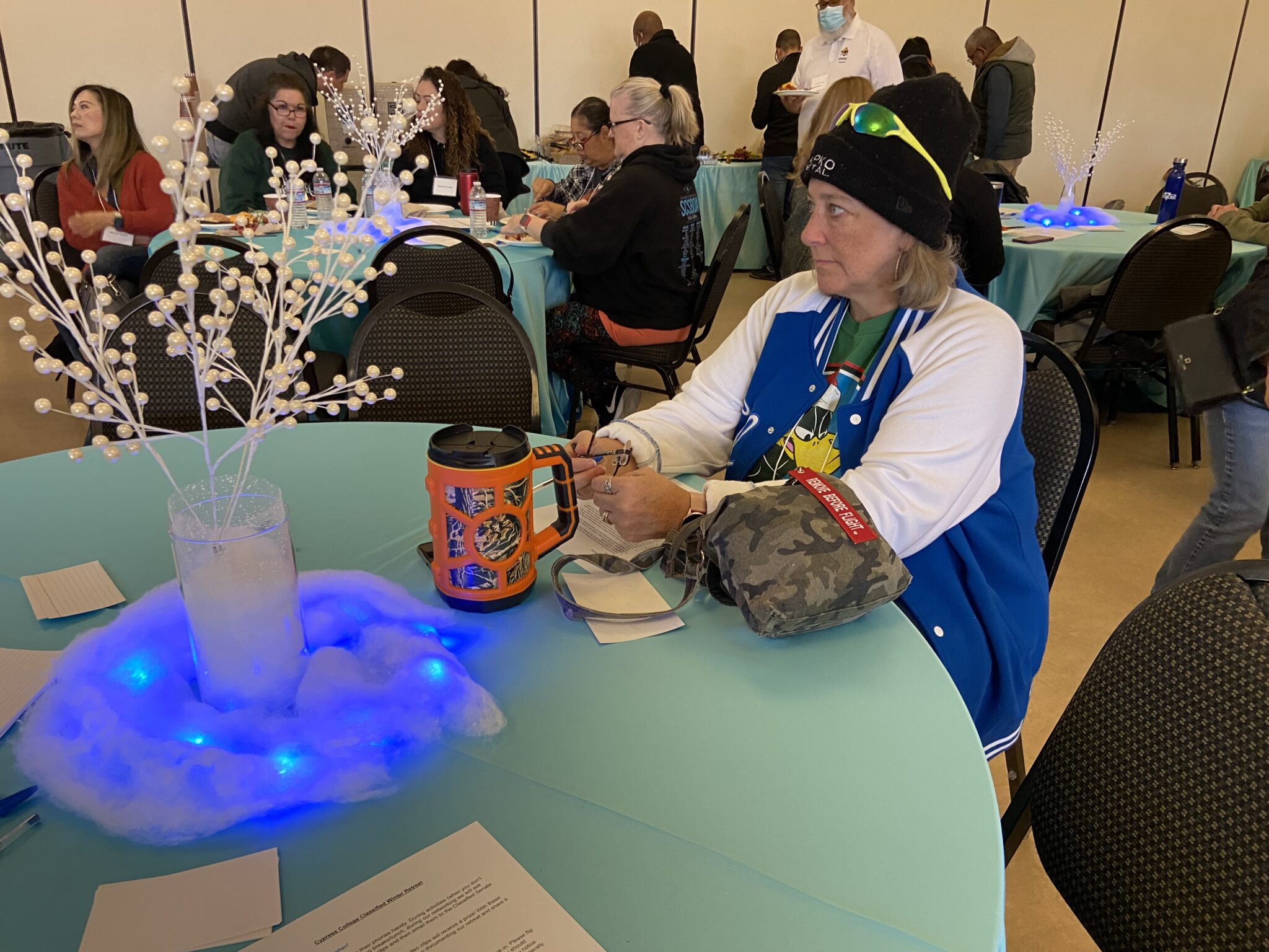 A classified staff member sitting at a winter themed decorated table and listening to the presentation.