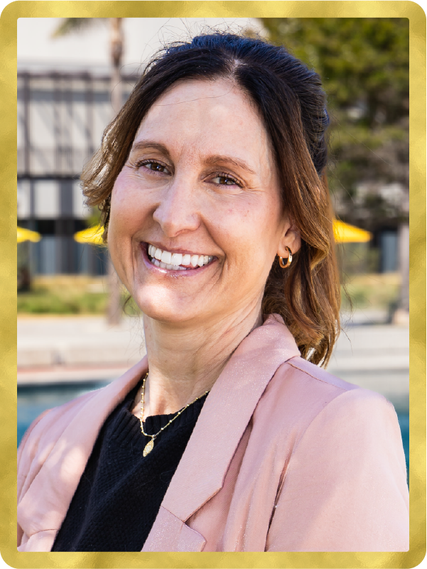 Portrait of Jennifer Coopman outside in a pink blazer