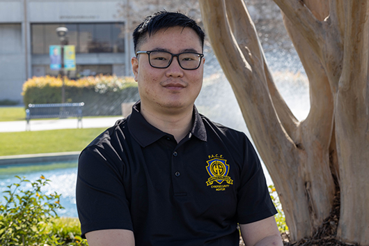 Dual Enrollment staff Benjamin Heng with pond in background