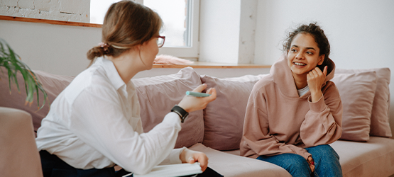 Two people sitting and talking on a couch