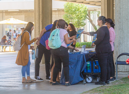 Students gathered at a table, taking folders