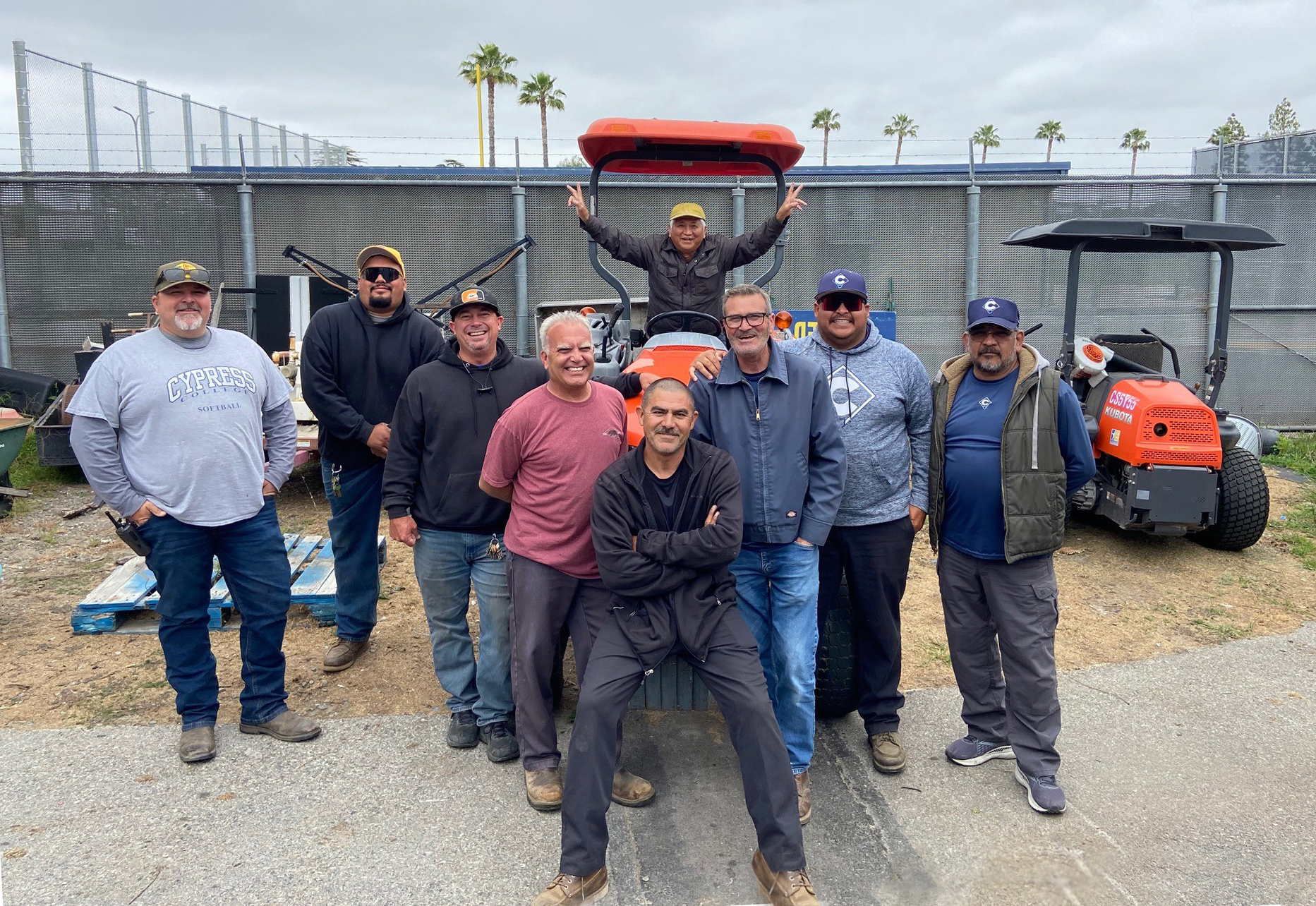 A group of staff members pose near equipment. 