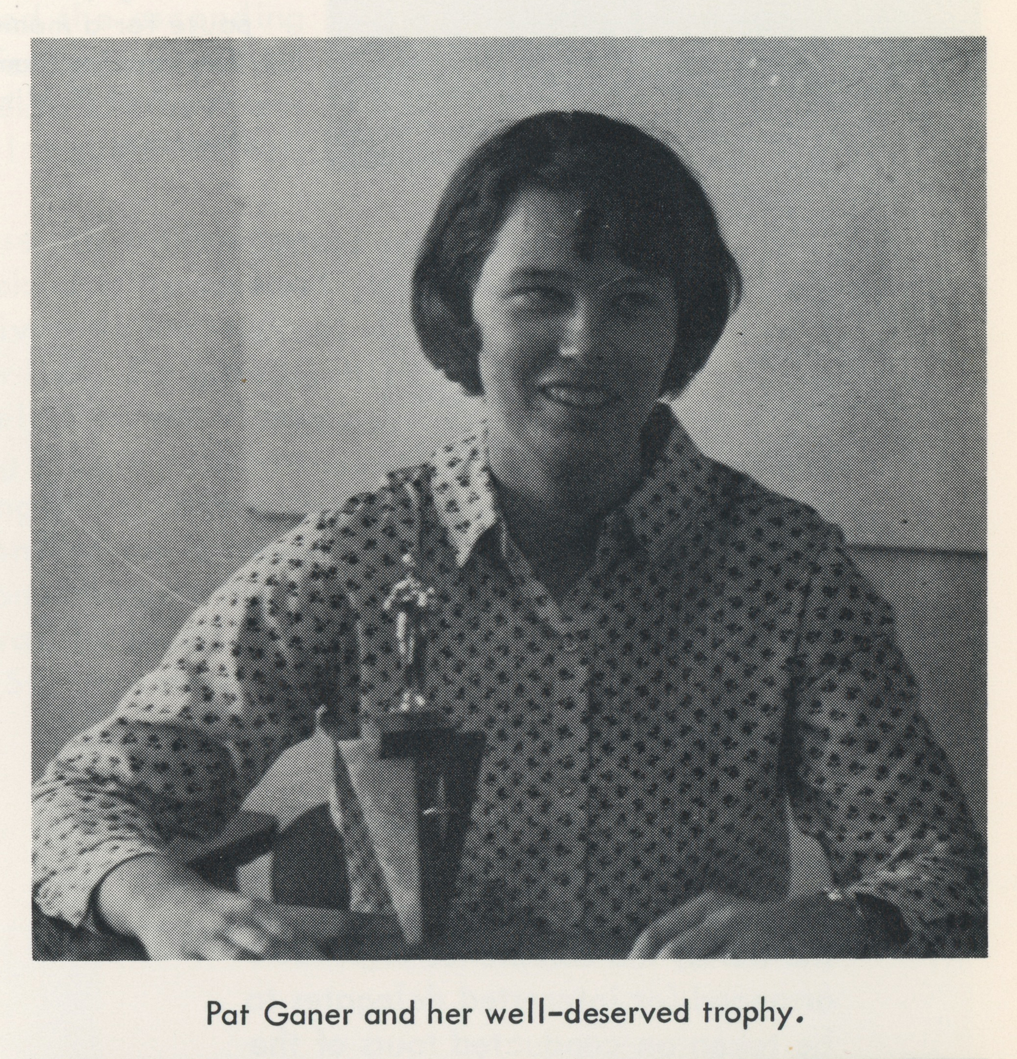 A young woman with a trophy. Black-and-white photo with a caption reading: Pat Ganer and her well-deserved trophy.