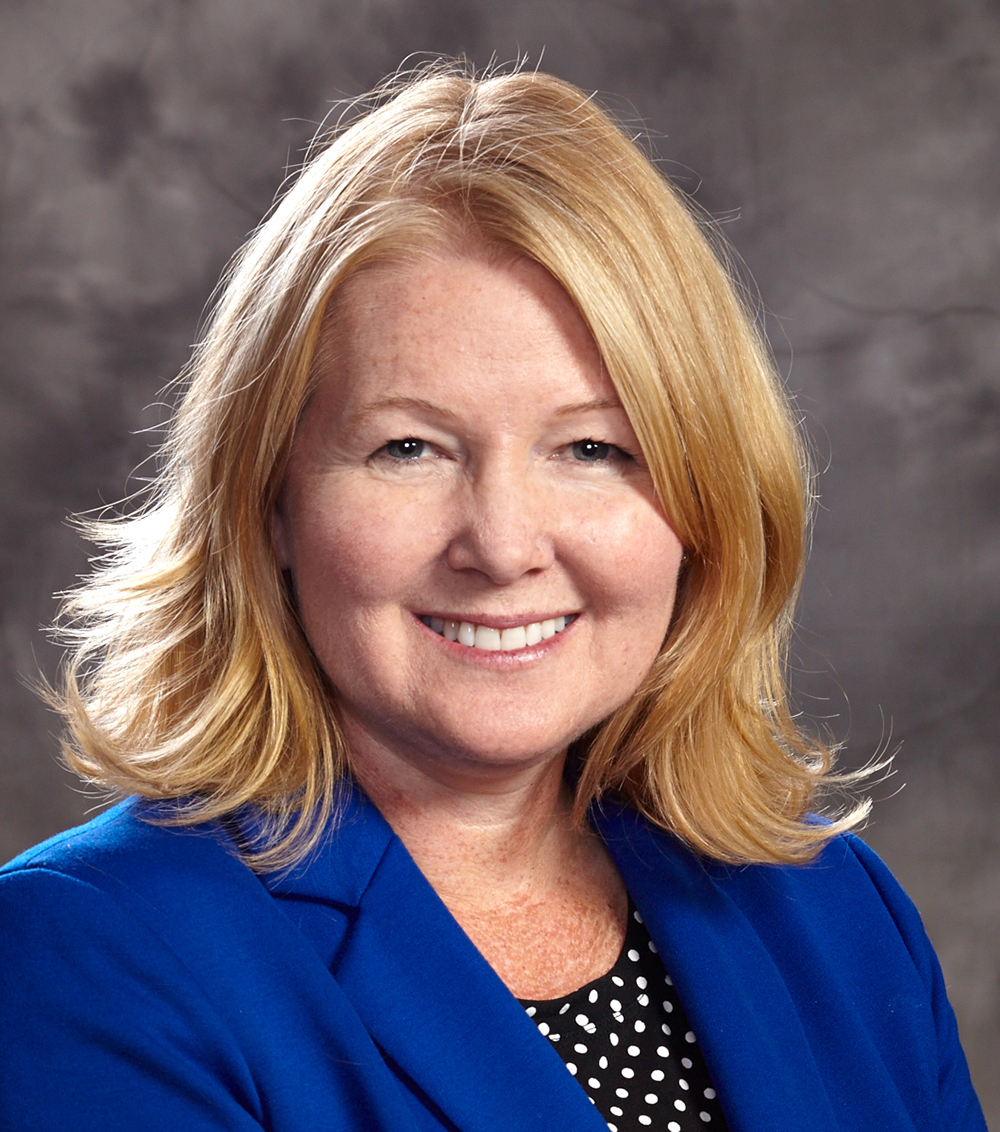 A woman smiles at the camera in a portrait.