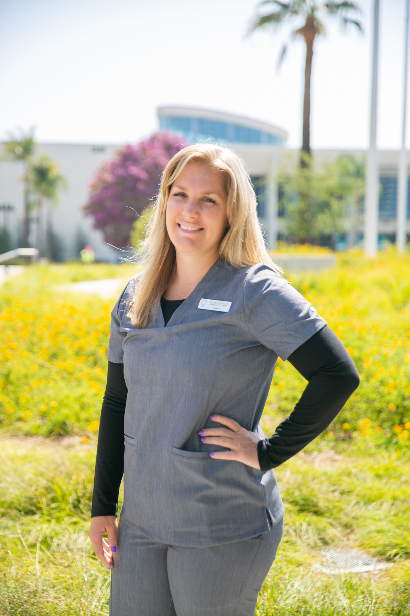 Emily Costello wears scrubs from the dental clinic as she stands on campus.