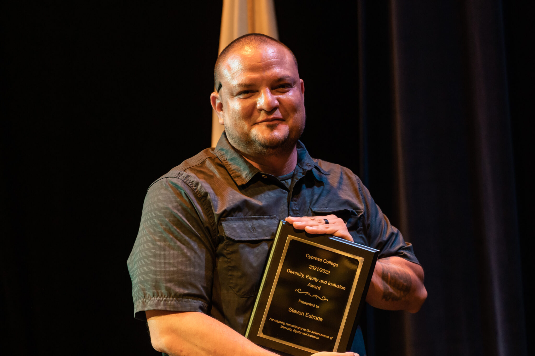 Professor Steven Estrada holding award