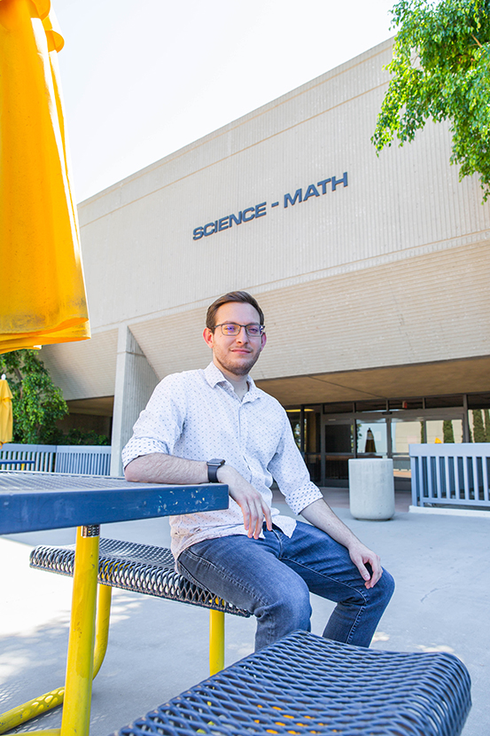Student Francisco Cornejo-Garcia sitting in front of the Science building