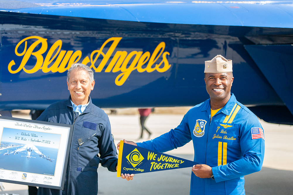 Ed Valdez holds a banner with Blue Angels pilot Justin Bratton.