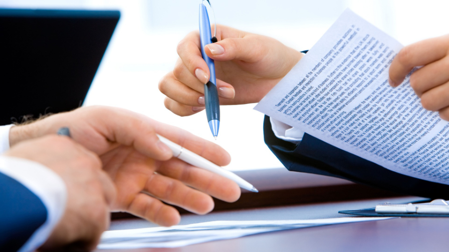 Two people signing paperwork