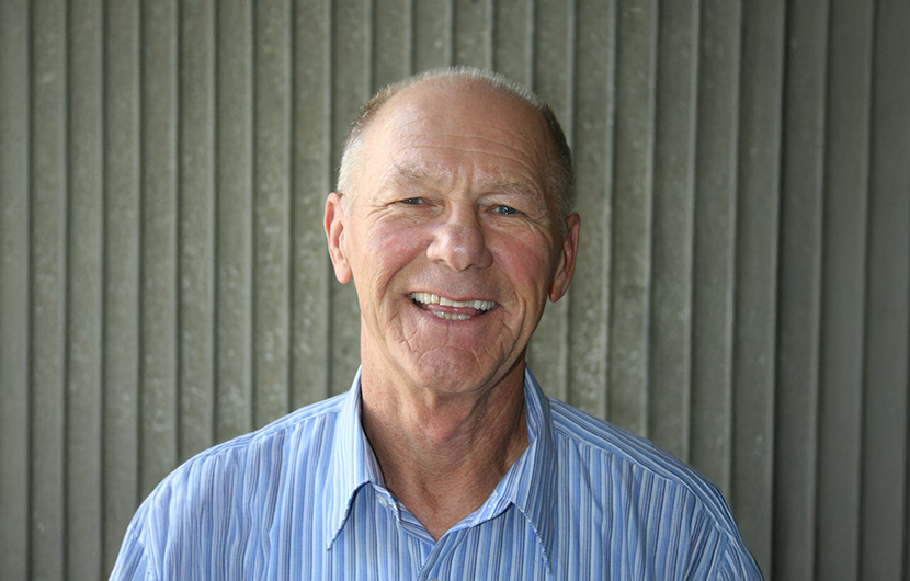 Older man in blue striped shirt smiles