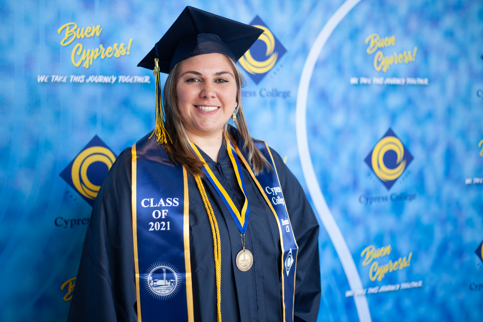 Student Jacklyn Williamson poses in front of blue wall as a Presidential Scholar of Distinction.