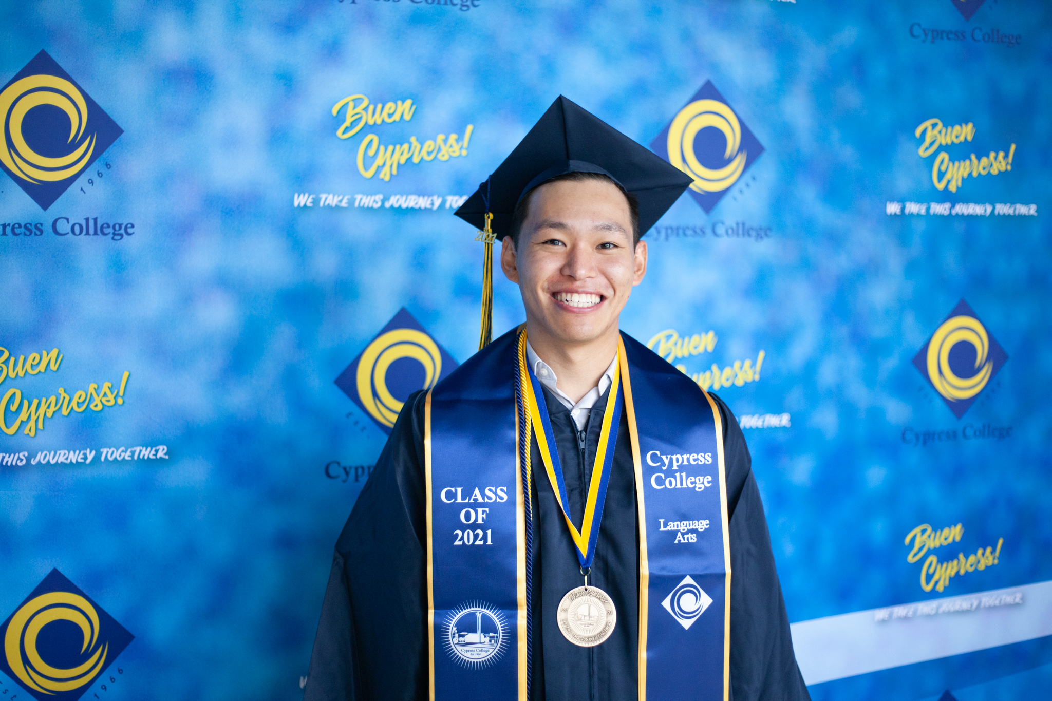 Hiroki Funahashi, Flight Attendant and Communications Studies student, poses in front of blue background.