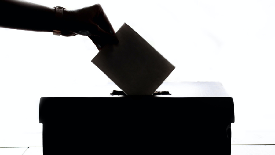 Person slipping paper ballot into a box