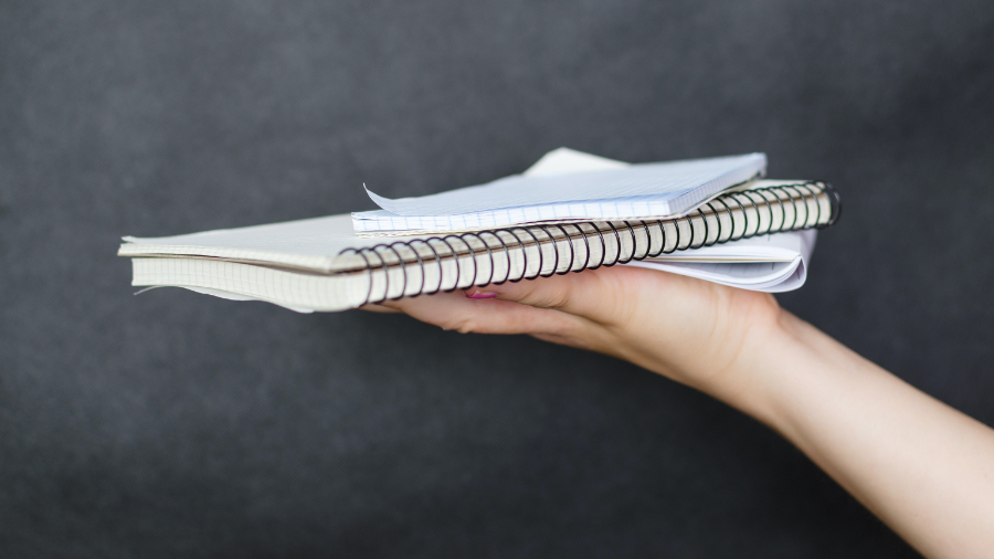 Person holding stack of books