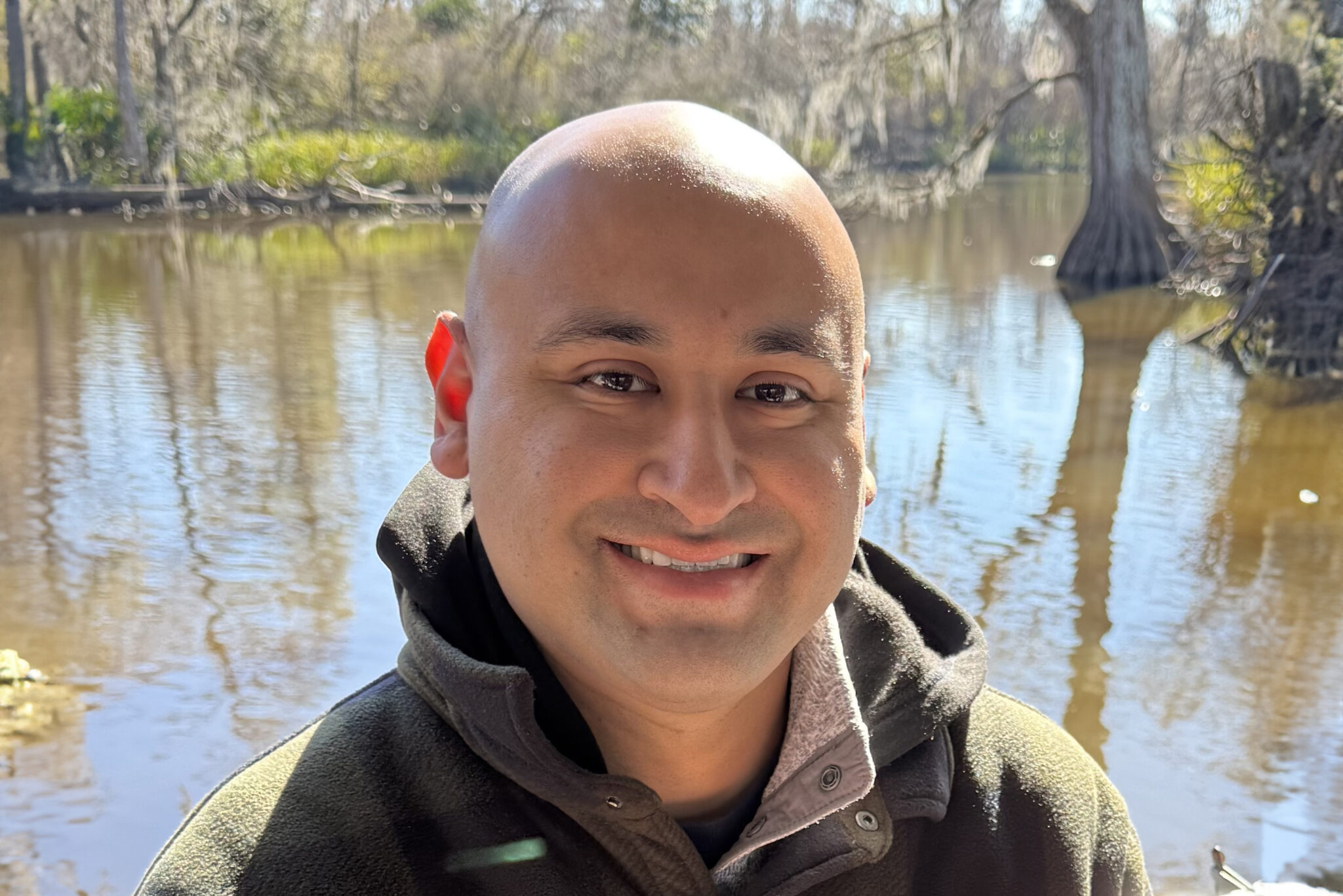 Teacher Shaun Galvan in front of pond