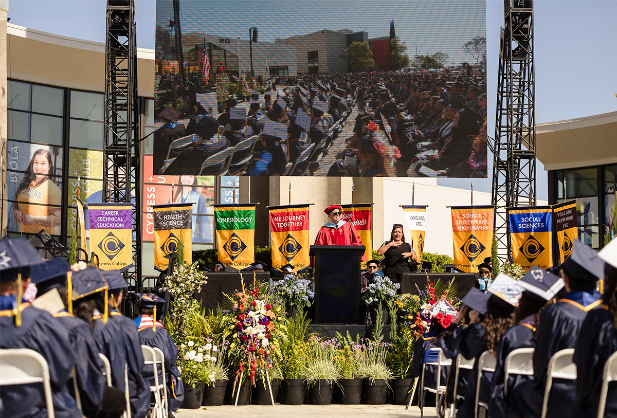 Cypress College President Dr. Scott W. Thayer stands on stage before hundreds of graduating students at the 58th commencement ceremony in front of the campanile
