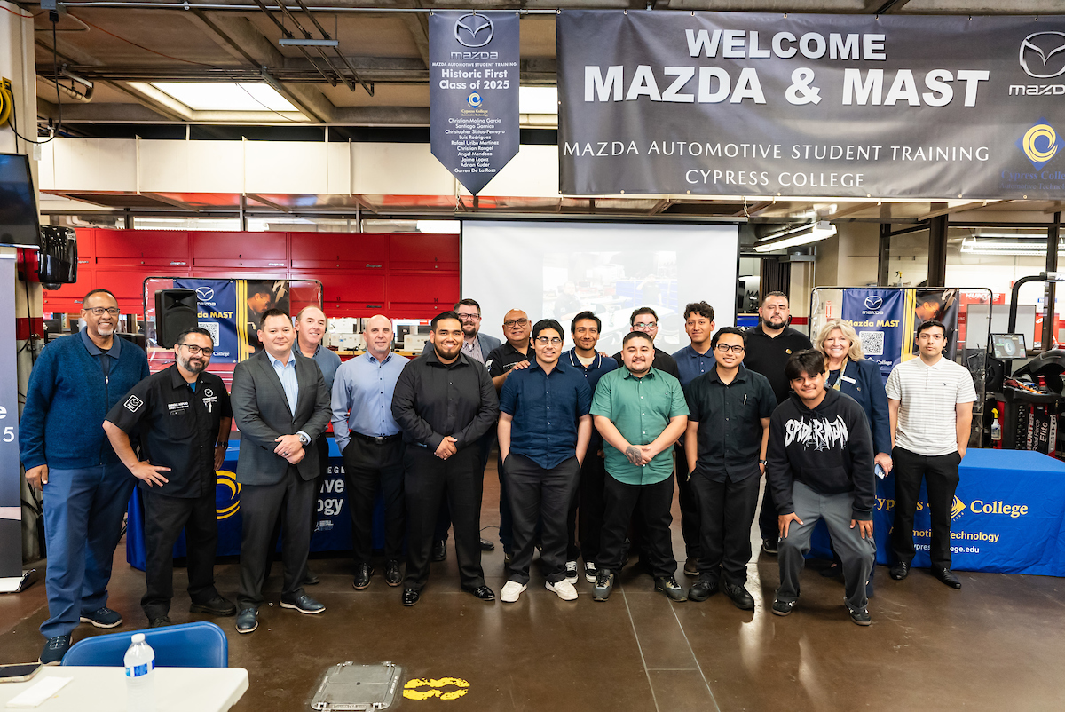 Ten graduating Auto Tech students stand in a line with faculty on either end