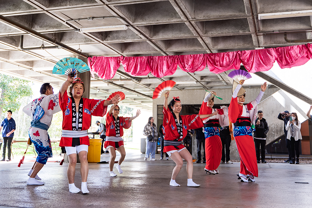 by Japanese Awa-Odori dance group Aozora-Ren wears traditional attire in red and waves fans.