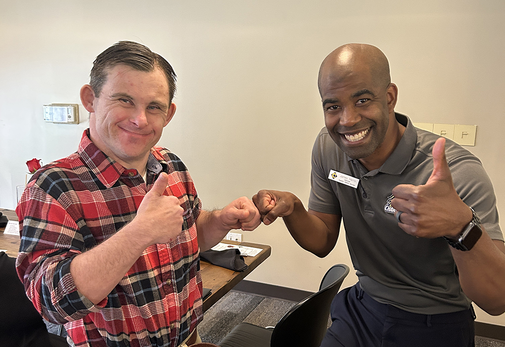 Two men give thumbs-ups to photographer as they pose in the Cypress Bistro.