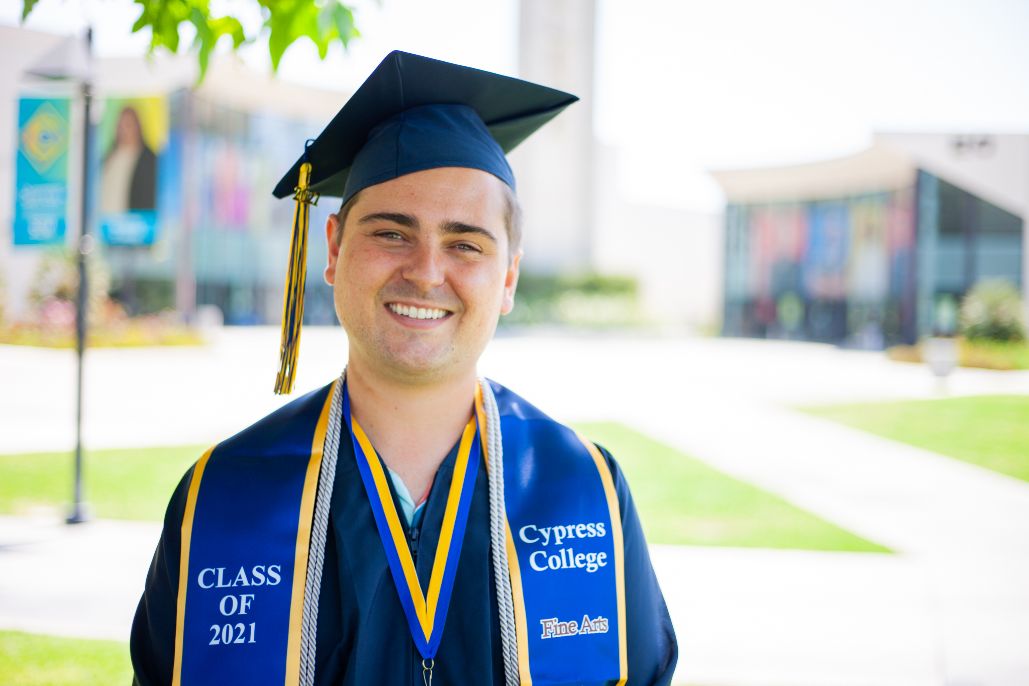 Film student Paul Scott poses in front of the campanile in graduation regalia.