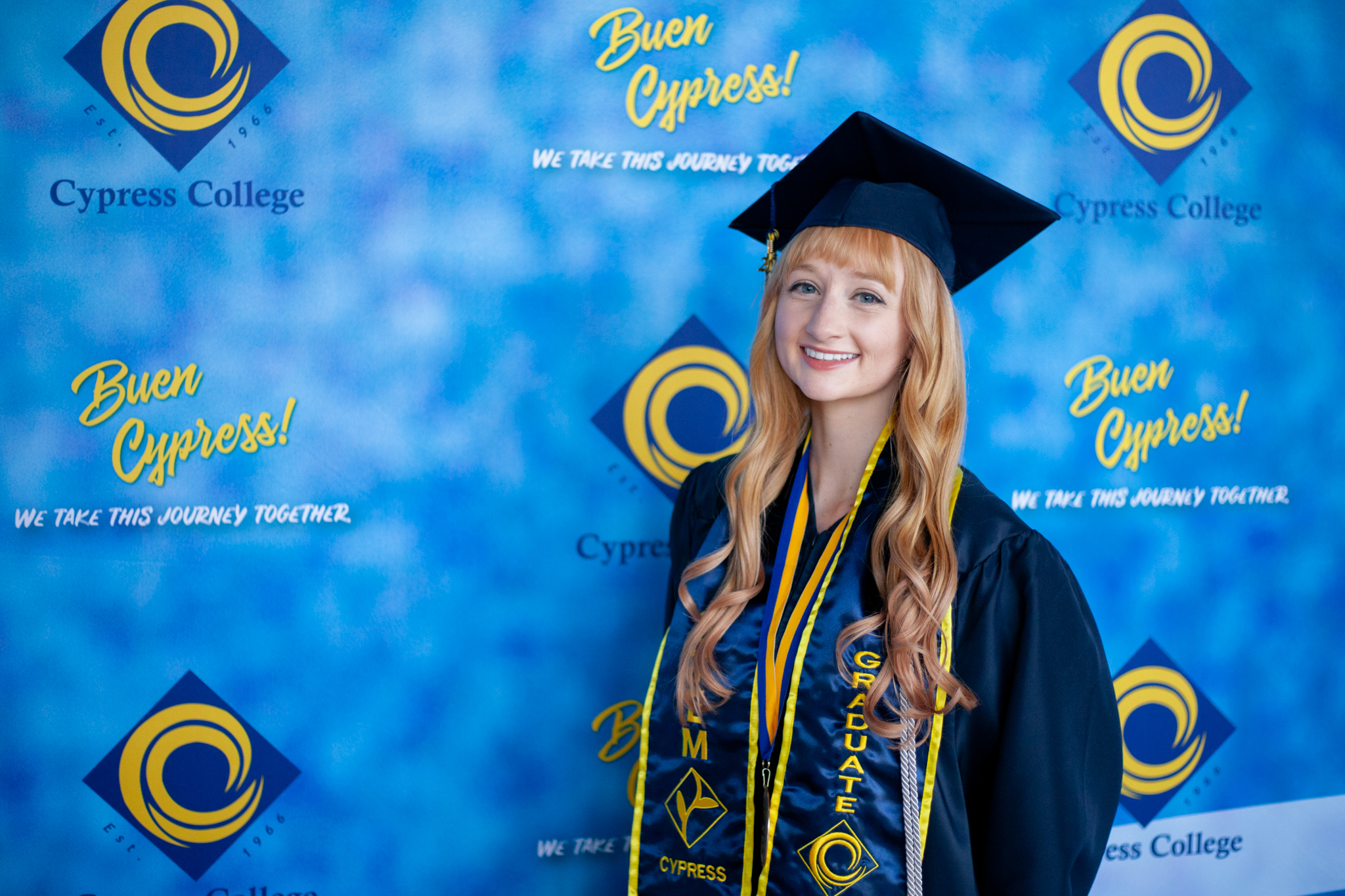 SEM student Lia Thompson poses in front of blue backdrop.