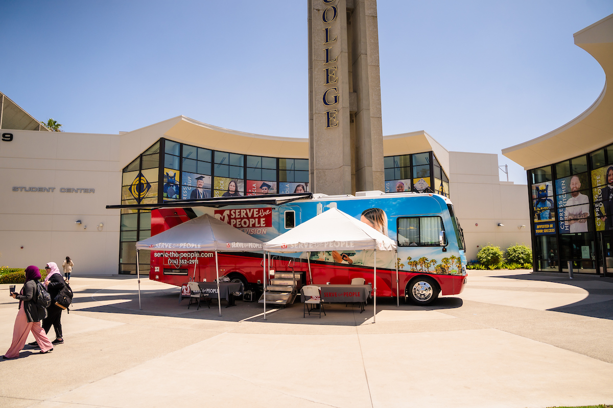 A mobile clinic van parked in front of the campanile
