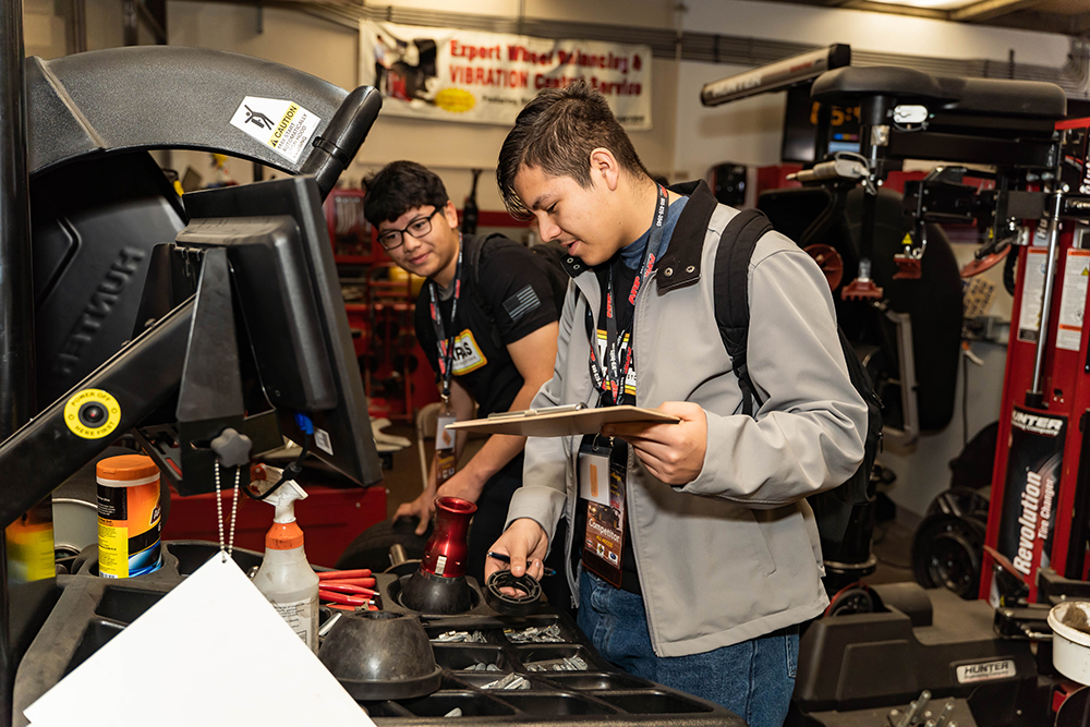 Two high school students participate in an auto skills challenge.