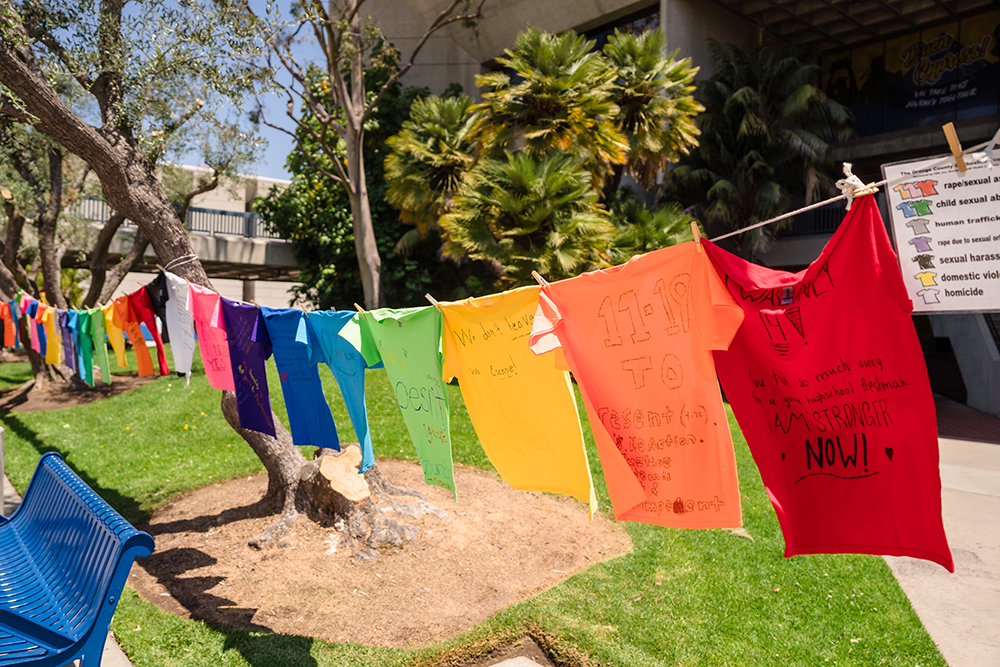 T-shirts in primary colors bearing words of encouragement fly from a clothesline.