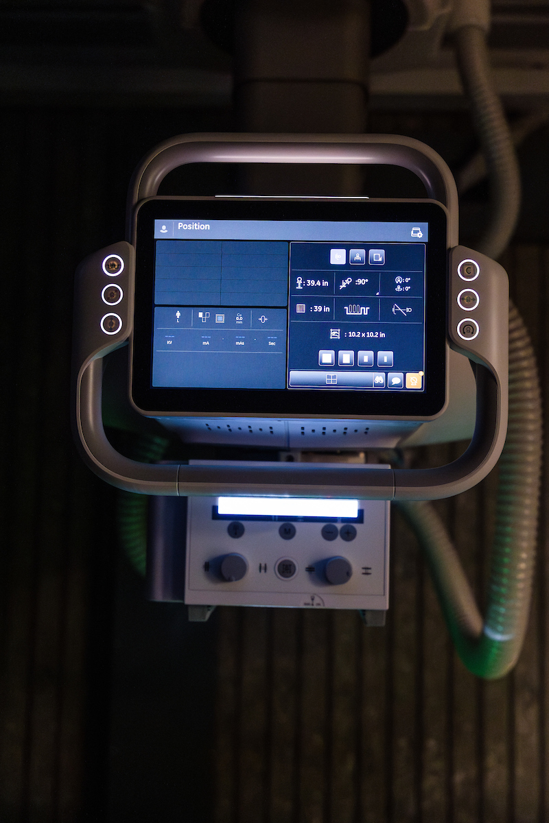 A screen for a new X-ray machine glows in a dark room
