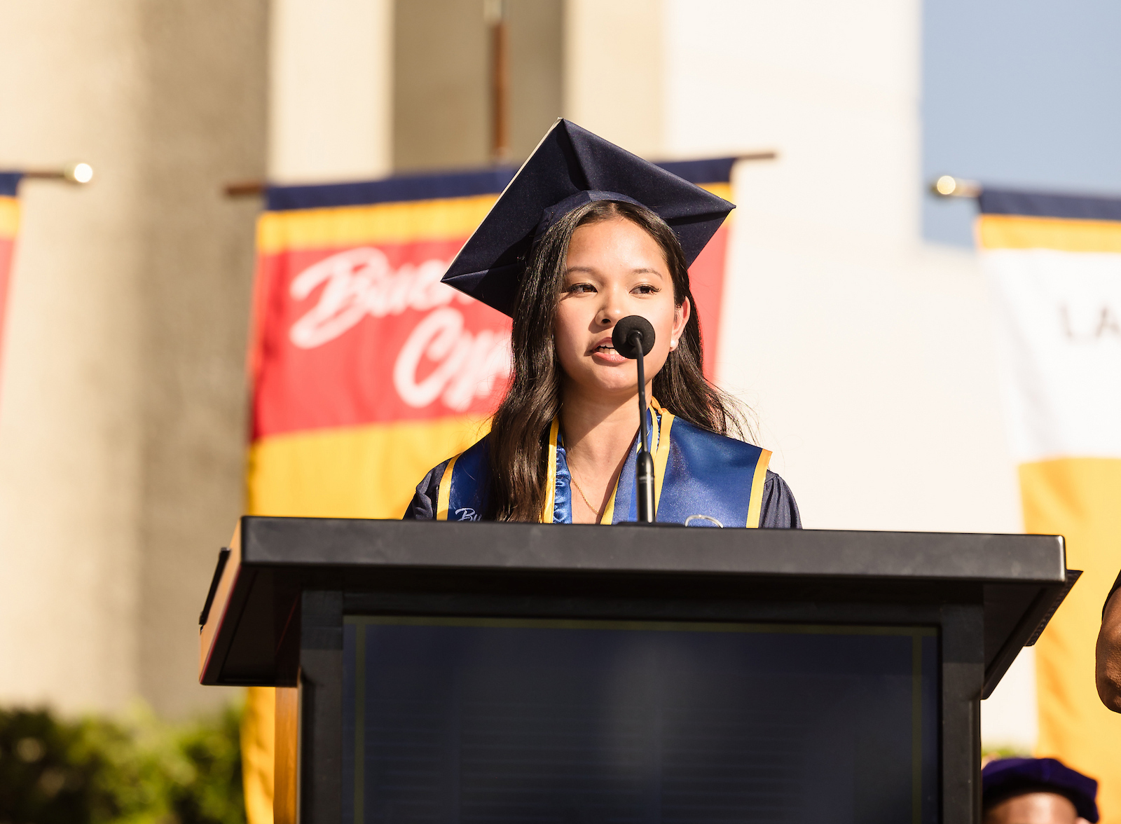 Outstanding graduate Hannah Kampitan addresses the commencement audience from the podium.