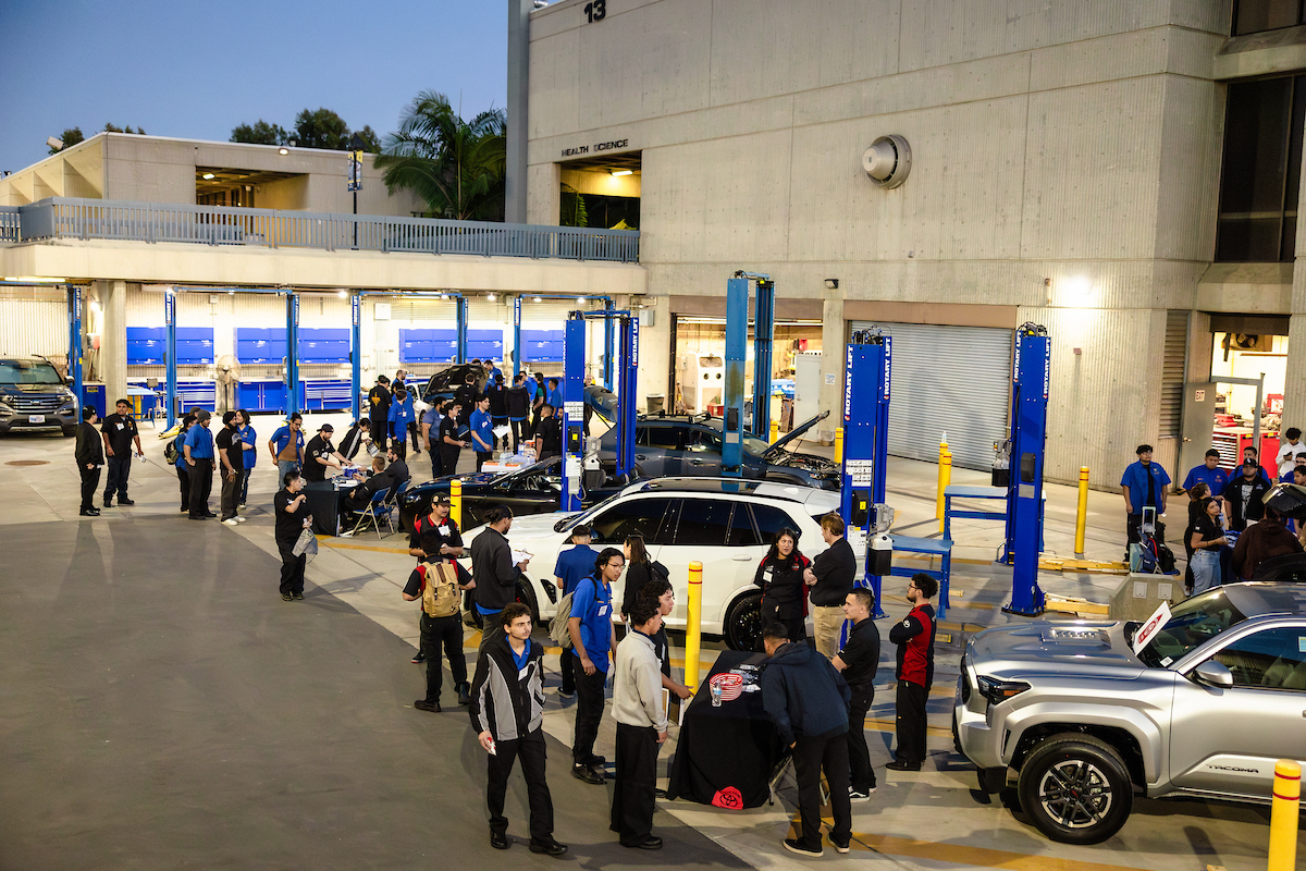 About 50 auto tech students walk through vendor tables in the auto tech/auto collision yard