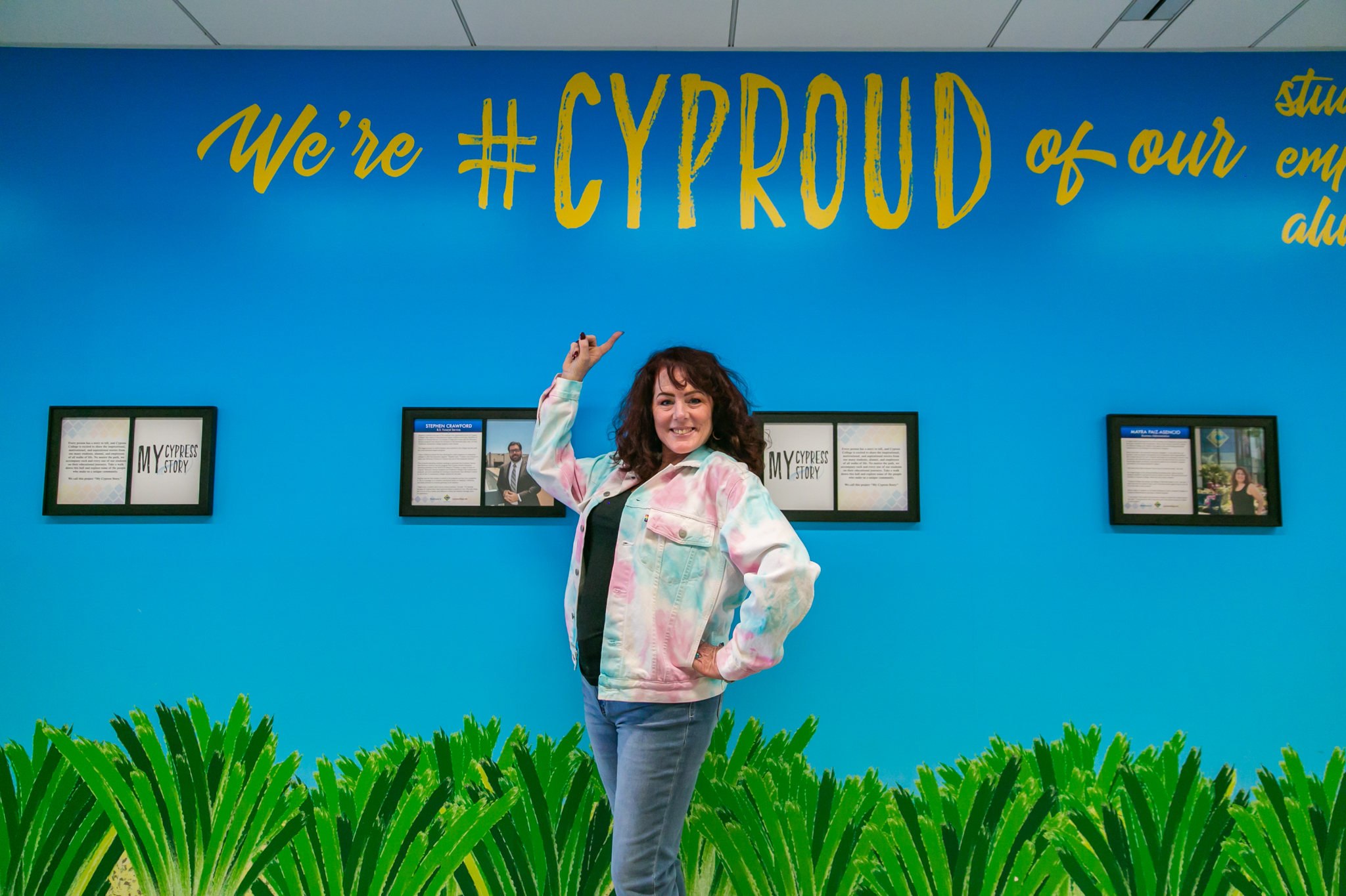 Lisa Plechner points to #CYProud wall in Humanities building.