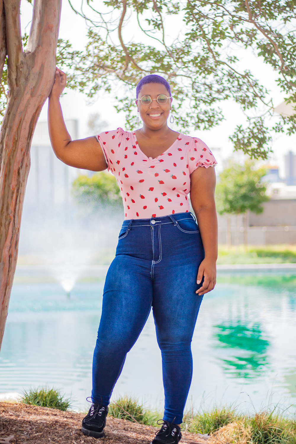 Raelynn Requena poses in casual clothes in front of the Cypress College pond.