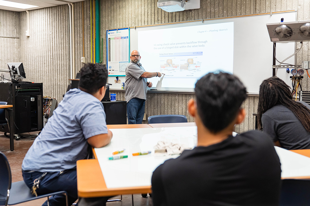John Lasater teaches students in an Air Conditioning and Refrigeration class using a projector for a lesson.