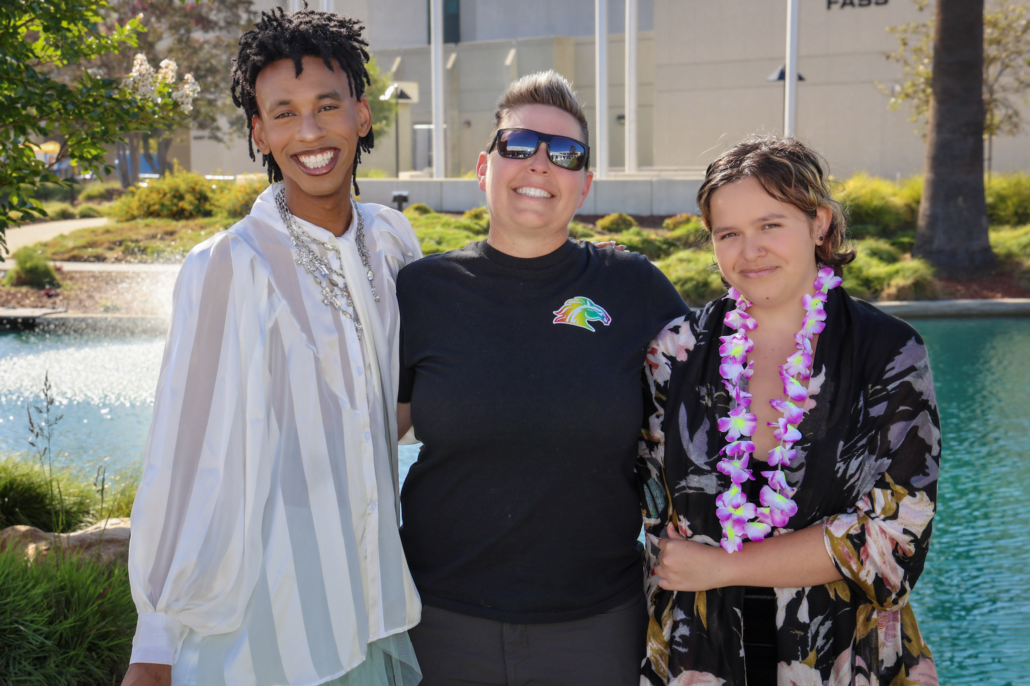 Three people smile for the camera