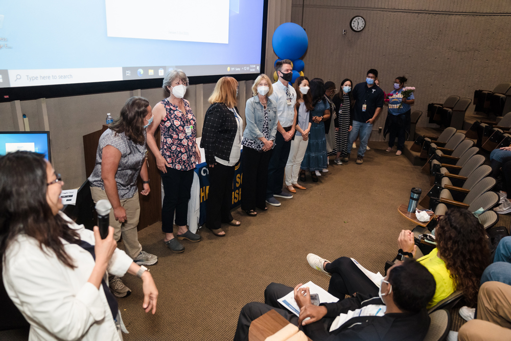 Nursing faculty line up in front of a classroom to be acknowledged for service. 