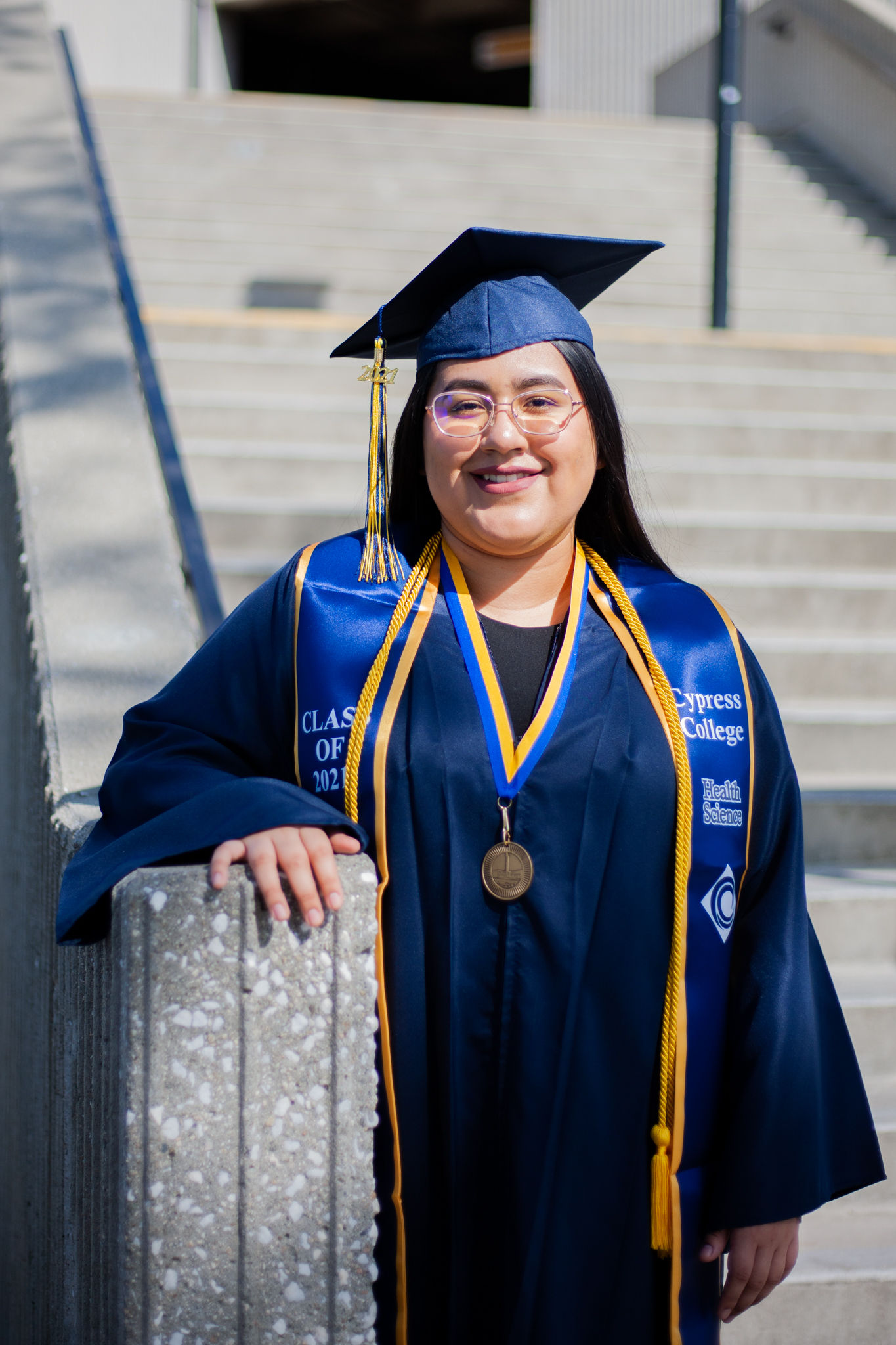Health Information Technology student Abigail Villegas stands beside a staircase on the Cypress College campus. 